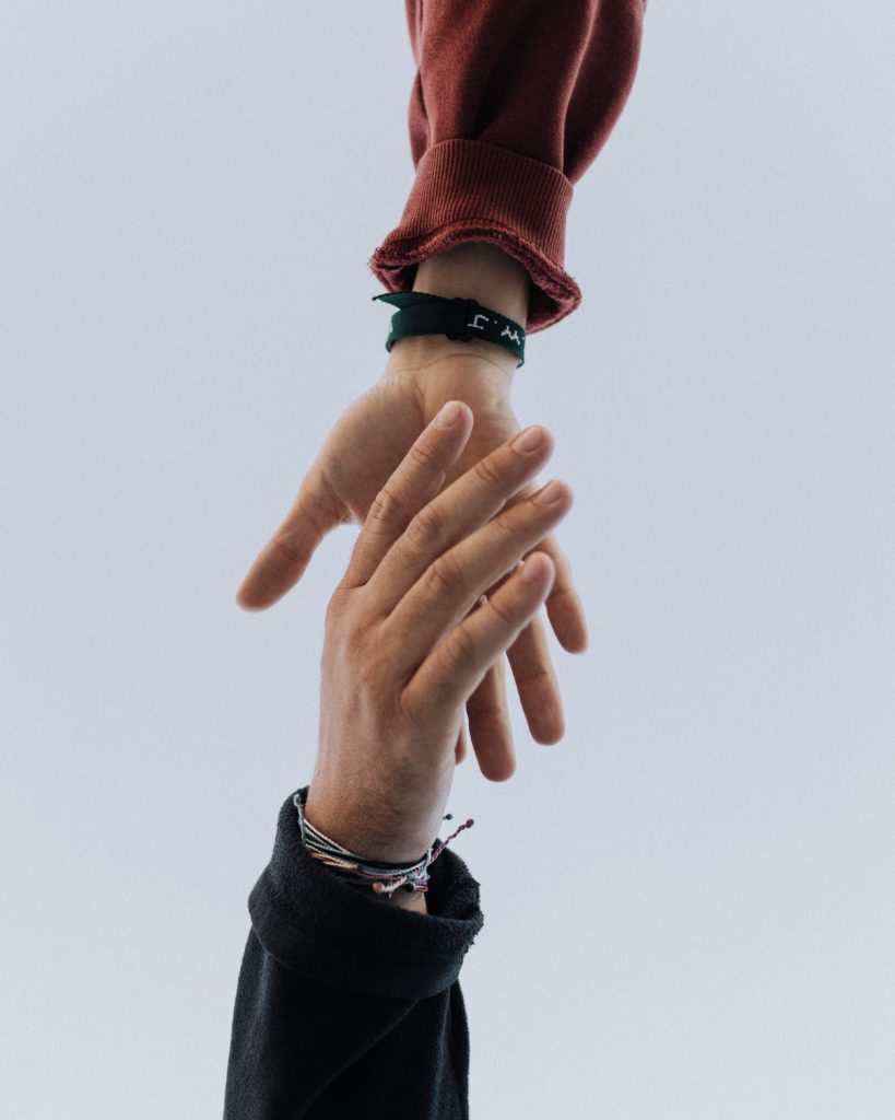 image of two hands - one hand reaching to help the other